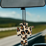 Cross-shaped hair-on-hide and leather car freshener charm, stitched design.