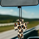 Cross-shaped hair-on-hide and leather car freshener charm, stitched design.