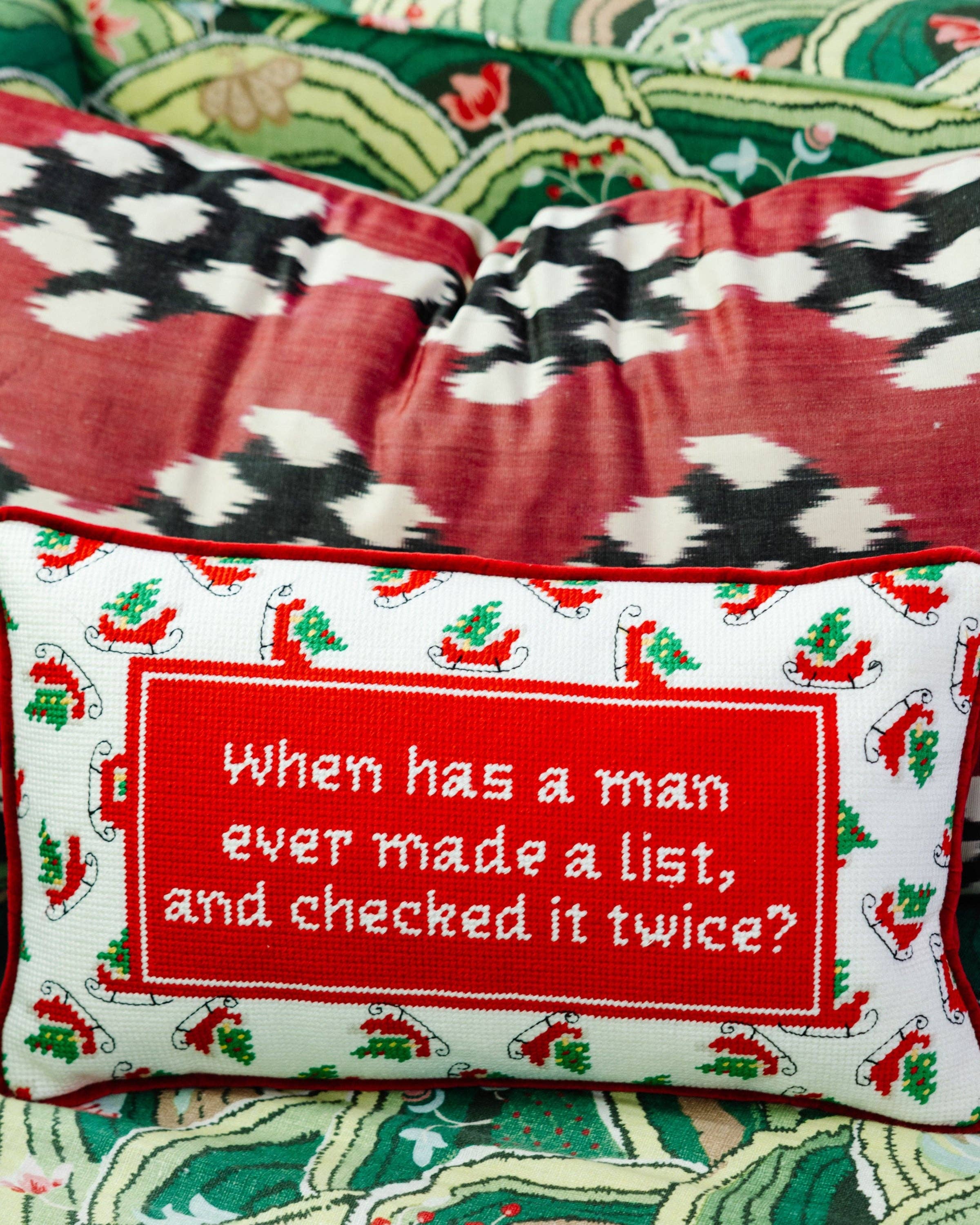 Red holiday needlepoint pillow with quote and festive holly border.