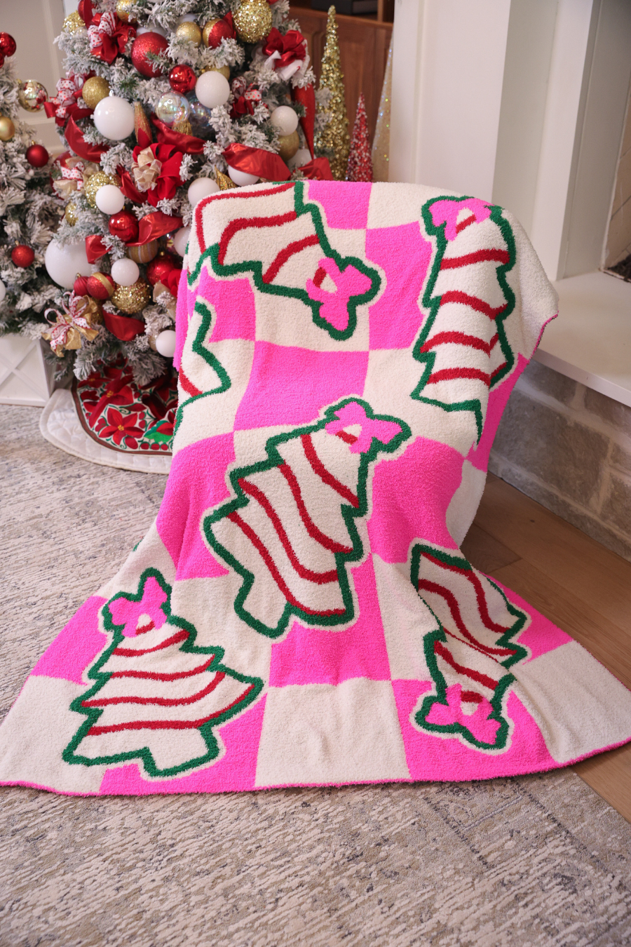 Pink checkered blanket with Christmas treats and pink bow design.