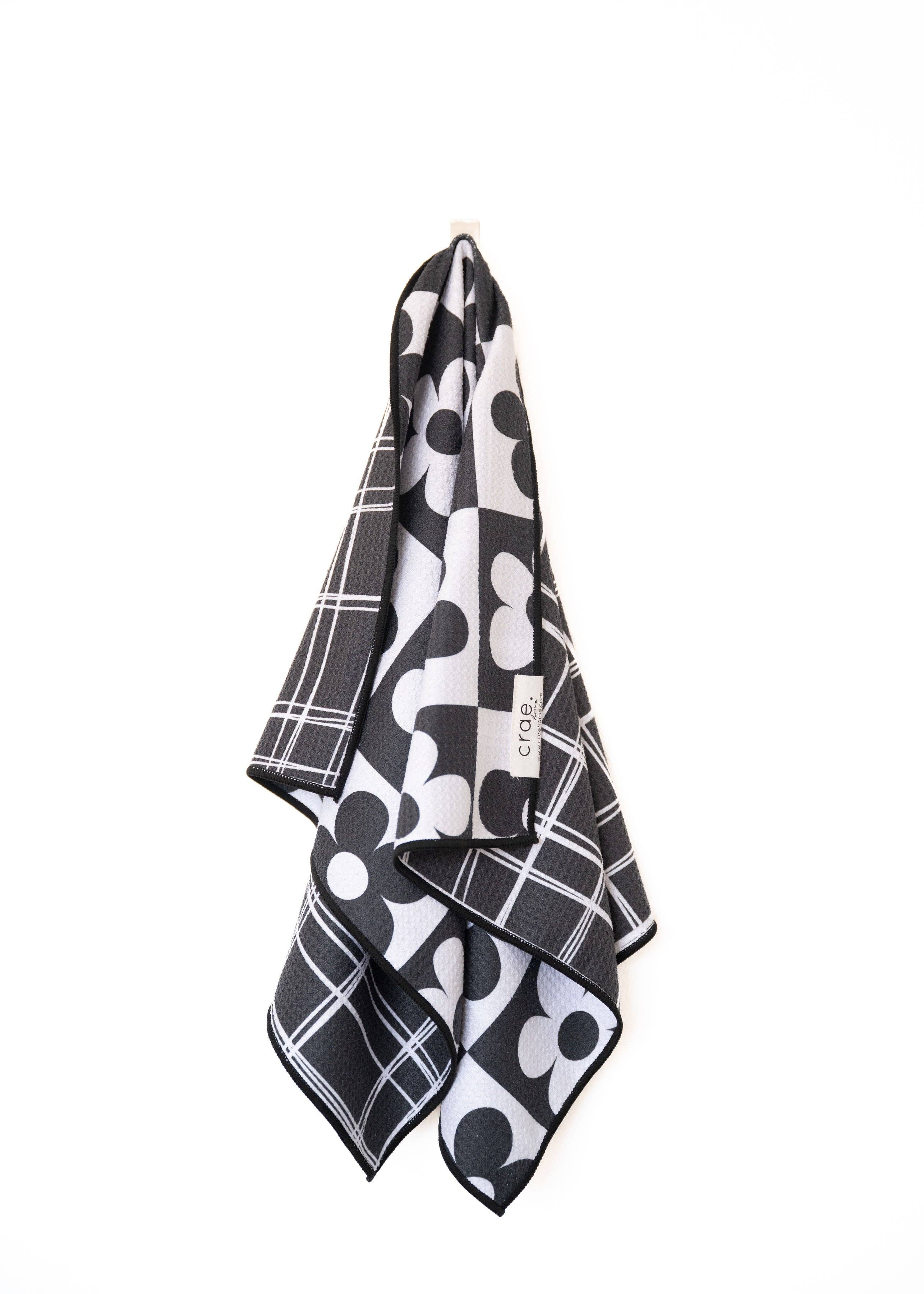 Crae 8 Track reversible microfiber hand towel, 19x29 in, daisy checkerboard front and black grid back.