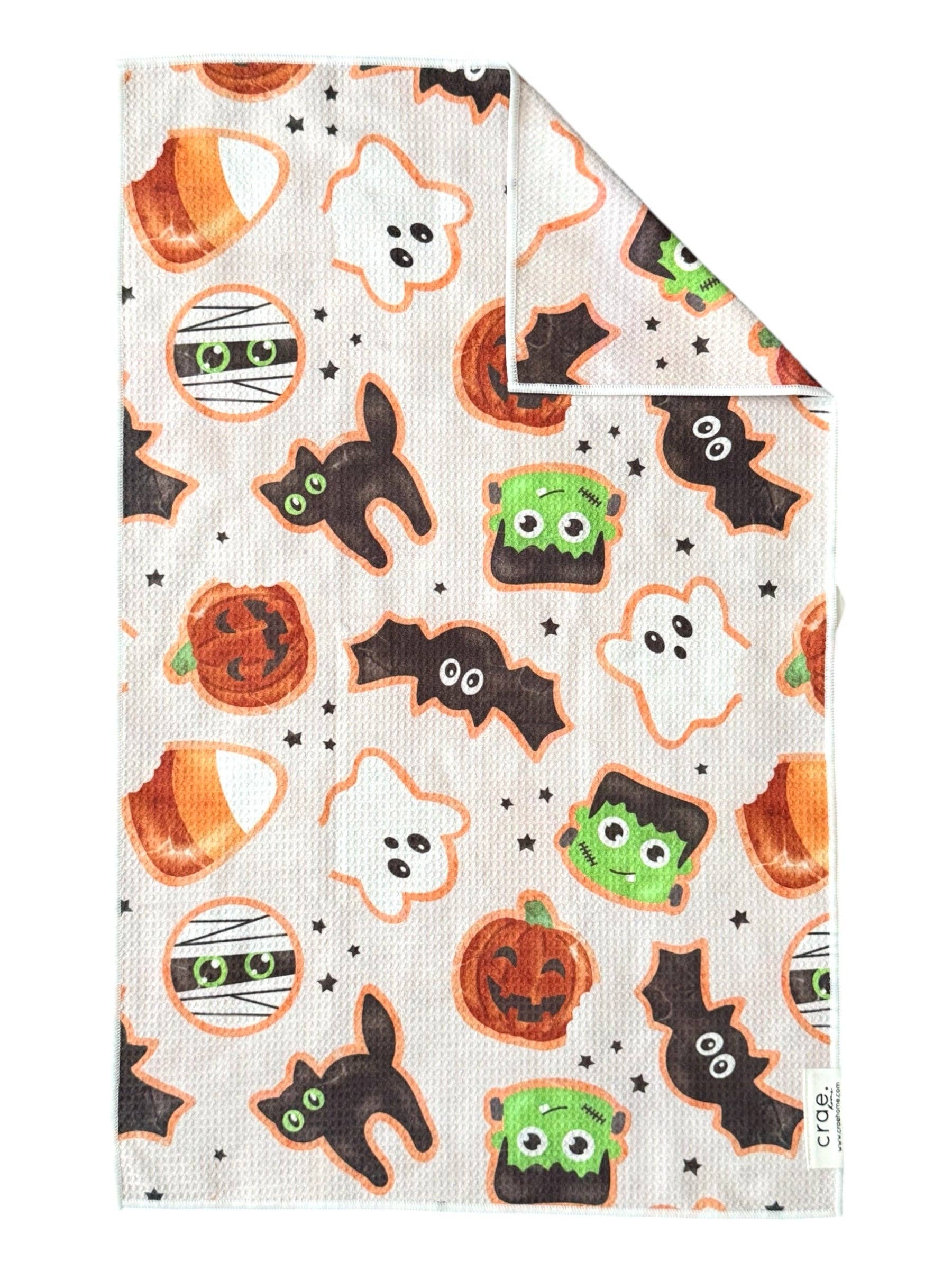 Crae Monster Munchies microfiber hand towel, 17x27 in, white with Halloween pumpkins, ghosts, bats, and candy corn.
