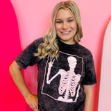 Black mineral wash tee with a pink peace sign skeleton graphic.