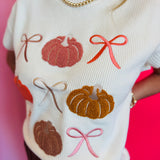 Lightweight knit sweater with rows of colorful pumpkins on a neutral base.