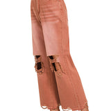 side view of Rust colored distressed knee jeans with raw hemline