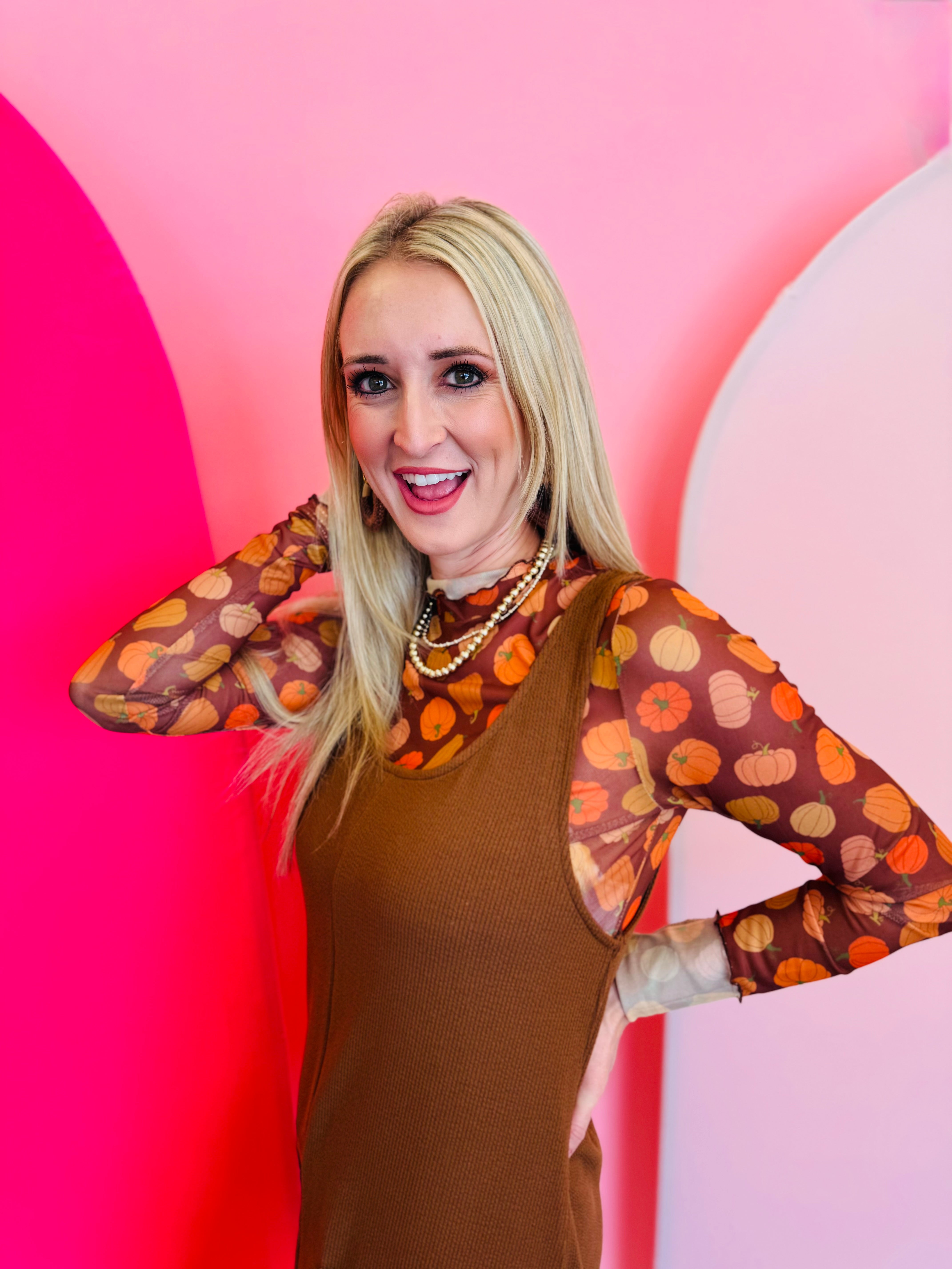 A sheer brown mesh top with a mock neck and colorful pumpkin print.