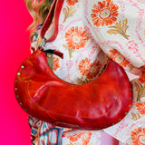 Edgy Bed Stu red studded leather shoulder bag with removable strap and slip pocket.