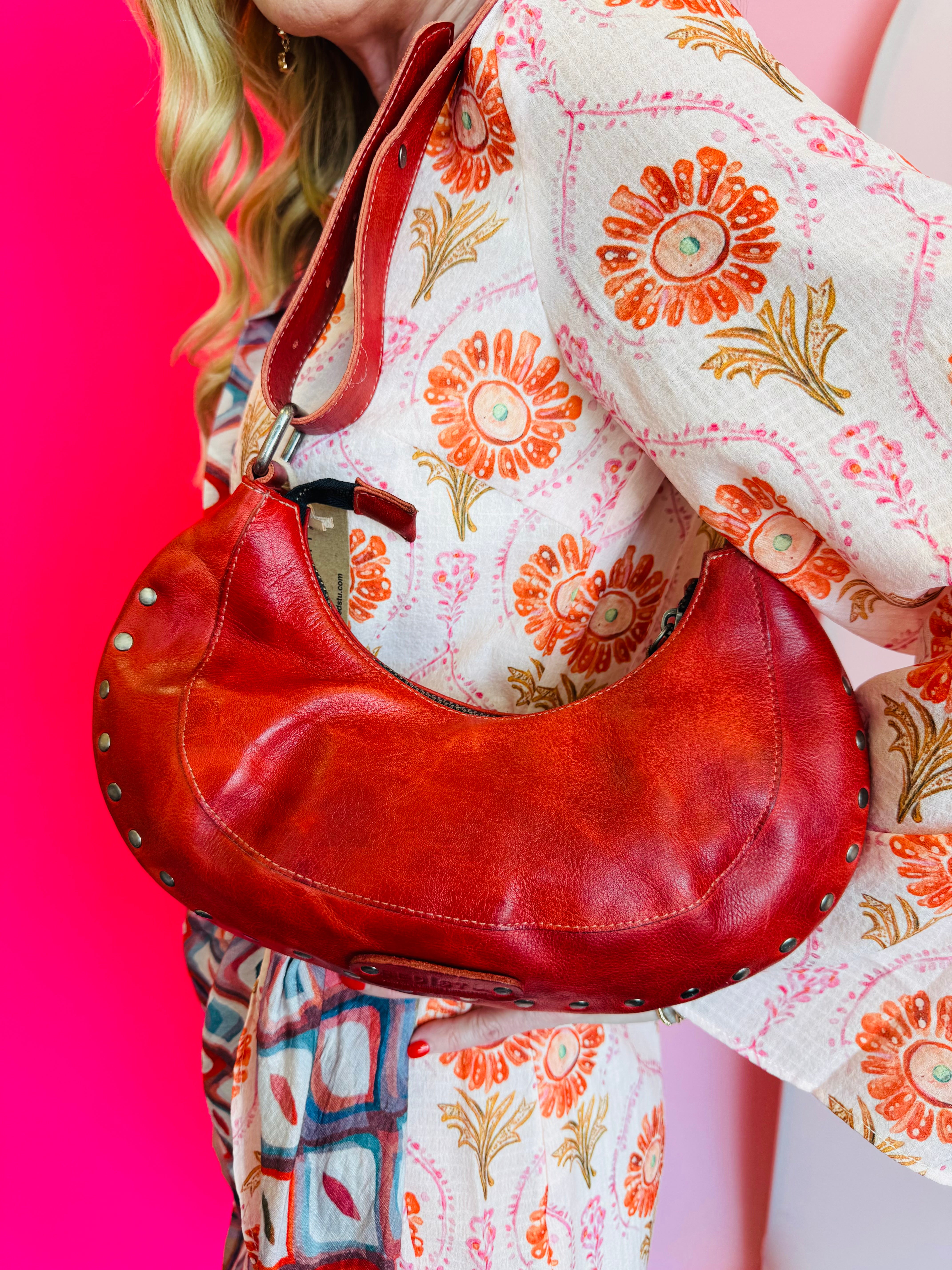 Edgy Bed Stu red studded leather shoulder bag with removable strap and slip pocket.