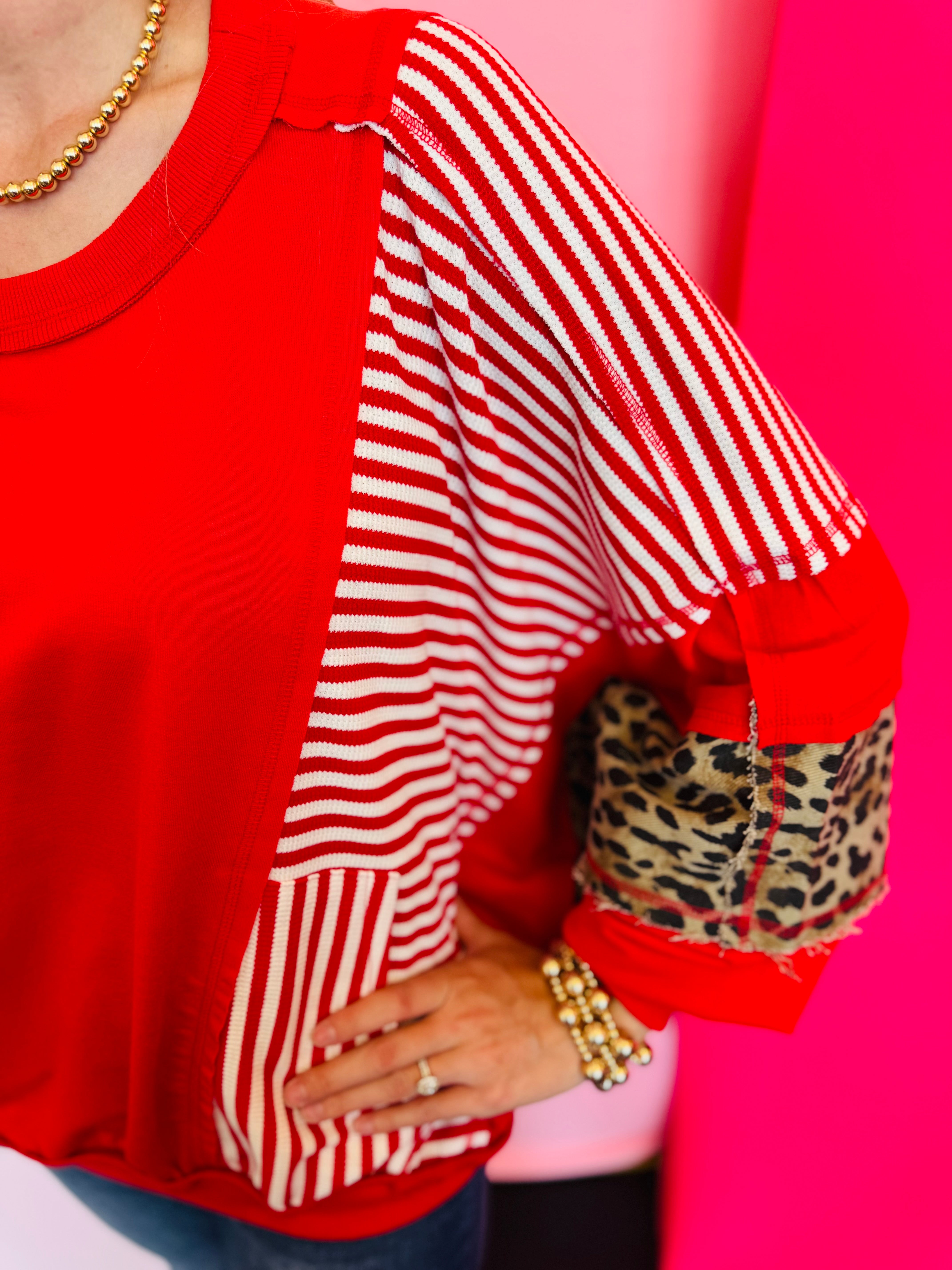 Close up of Red, stripe, and leopard oversized Dolman style long sleeve sweatshirt.