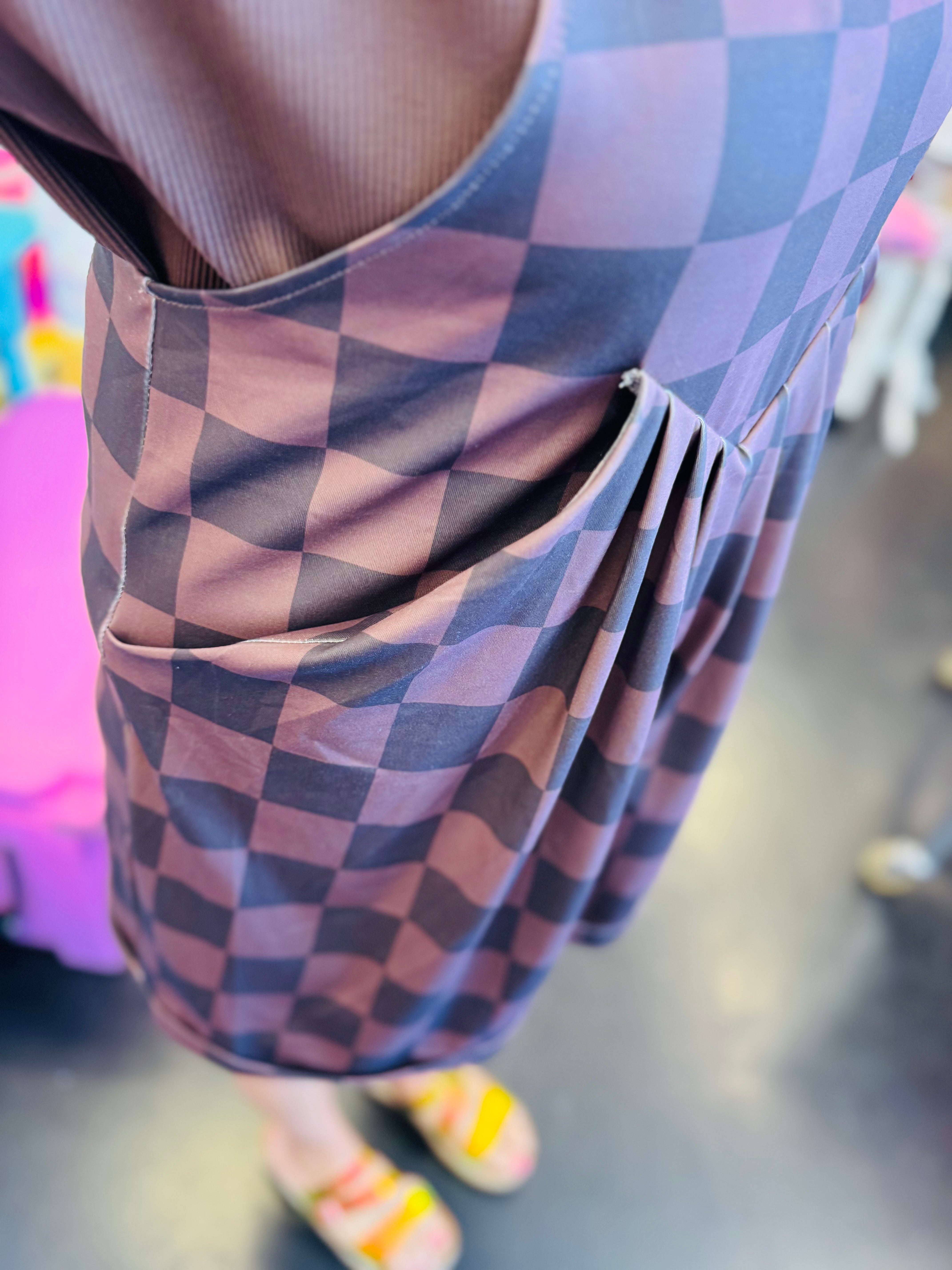 side pleats of chocolate checkered overall shorts