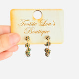 Gold hoop earrings with filigree beads, decorated with dark green emerald stones along a golden wire hoop