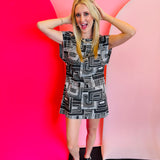 Black and white geometric print mini dress with structured shoulders and an open back.