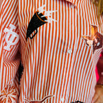Close up of Queen Of Sparkles orange and white striped icon University Of Texas game day blouse.