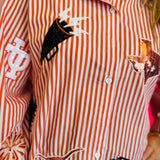 Close up of Queen Of Sparkles orange and white striped icon University Of Texas game day blouse.