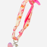 Pink and ivory floral scarf necklace with puffy pink heart charm and silver heart charm, tied in a stylish knot and designed to be worn as a necklace, bracelet, or accessory.
