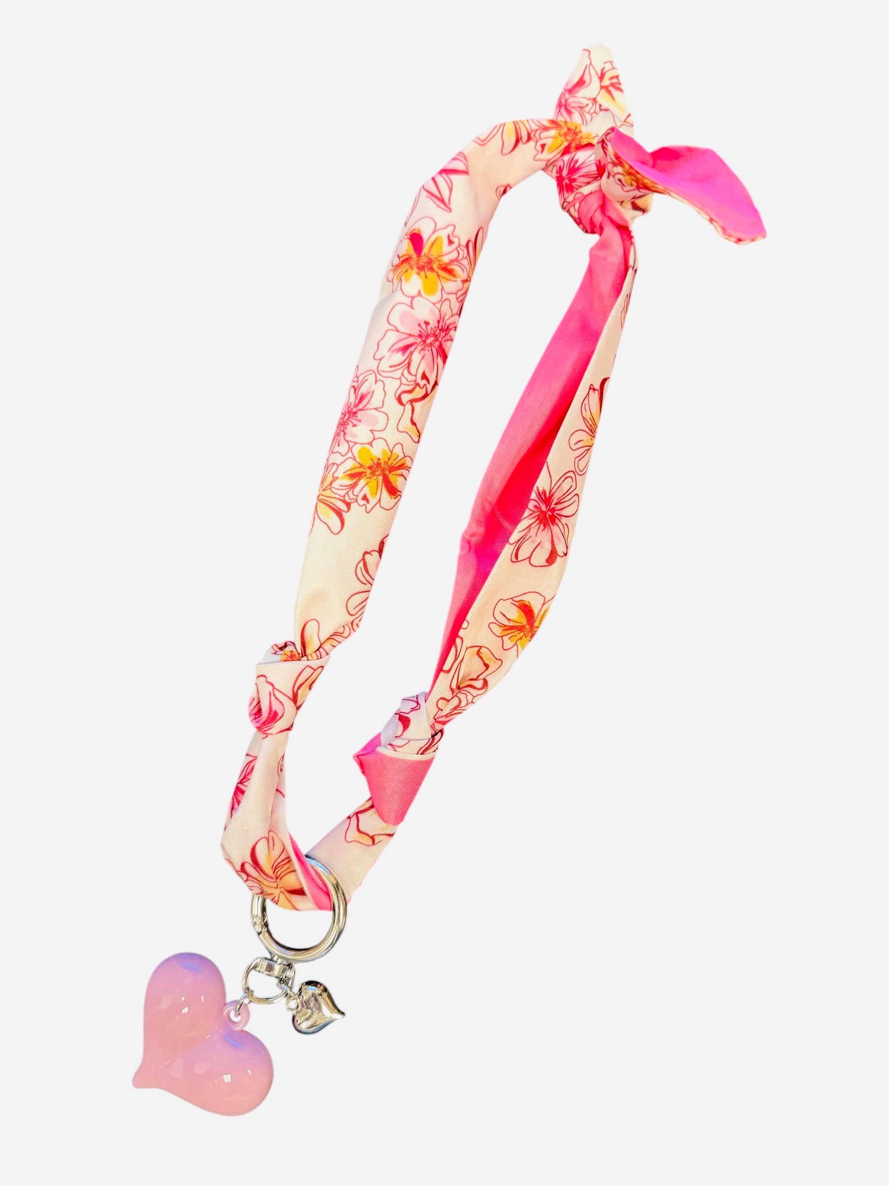 Pink and ivory floral scarf necklace with puffy pink heart charm and silver heart charm, tied in a stylish knot and designed to be worn as a necklace, bracelet, or accessory.