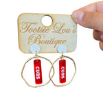 Gold  hoop earrings with red dangles and white writing that says Cubs set on a white stud