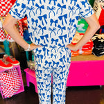White pajama set with soft blue bow print, featuring a relaxed-fit short-sleeve top and matching pants made from lightweight, stretchy fabric for cozy comfort.