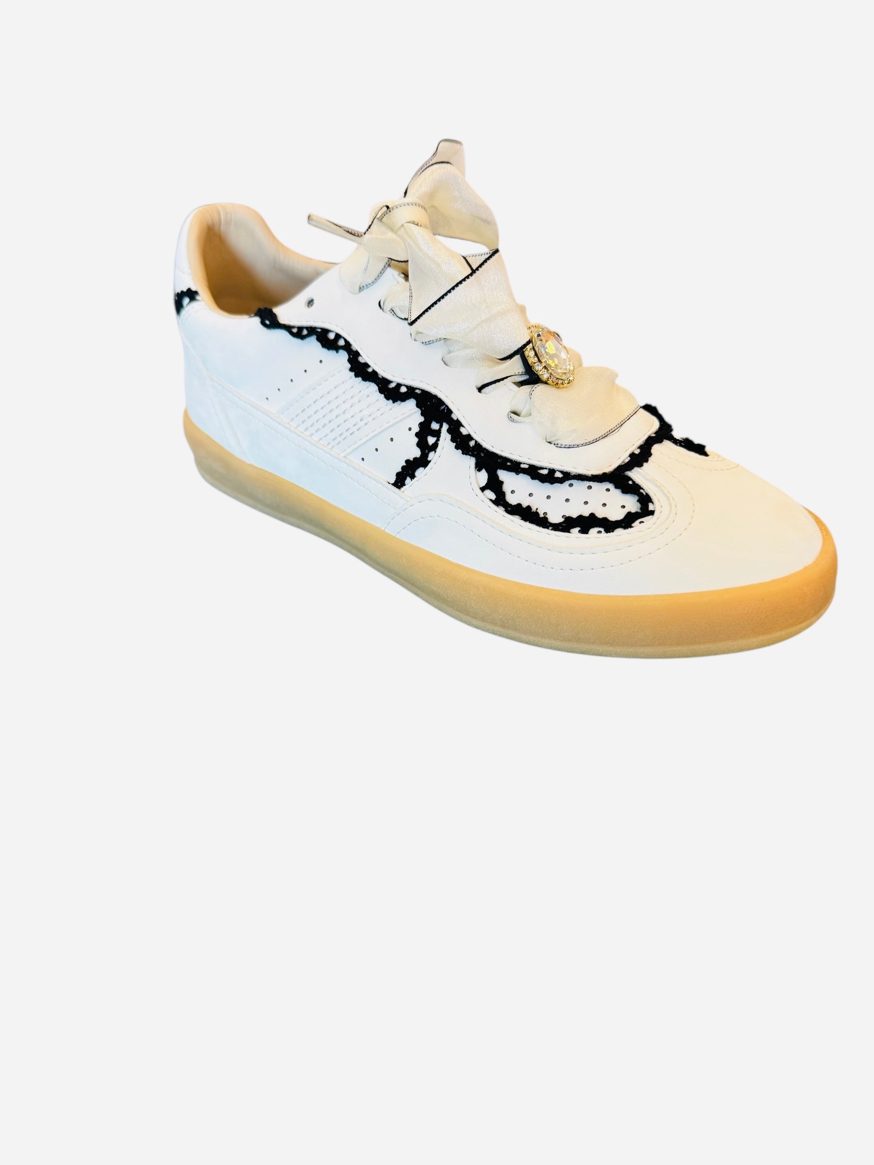 White low-top sneakers with vegan leather upper, delicate lace trim, lace-up closure, and round toe.
