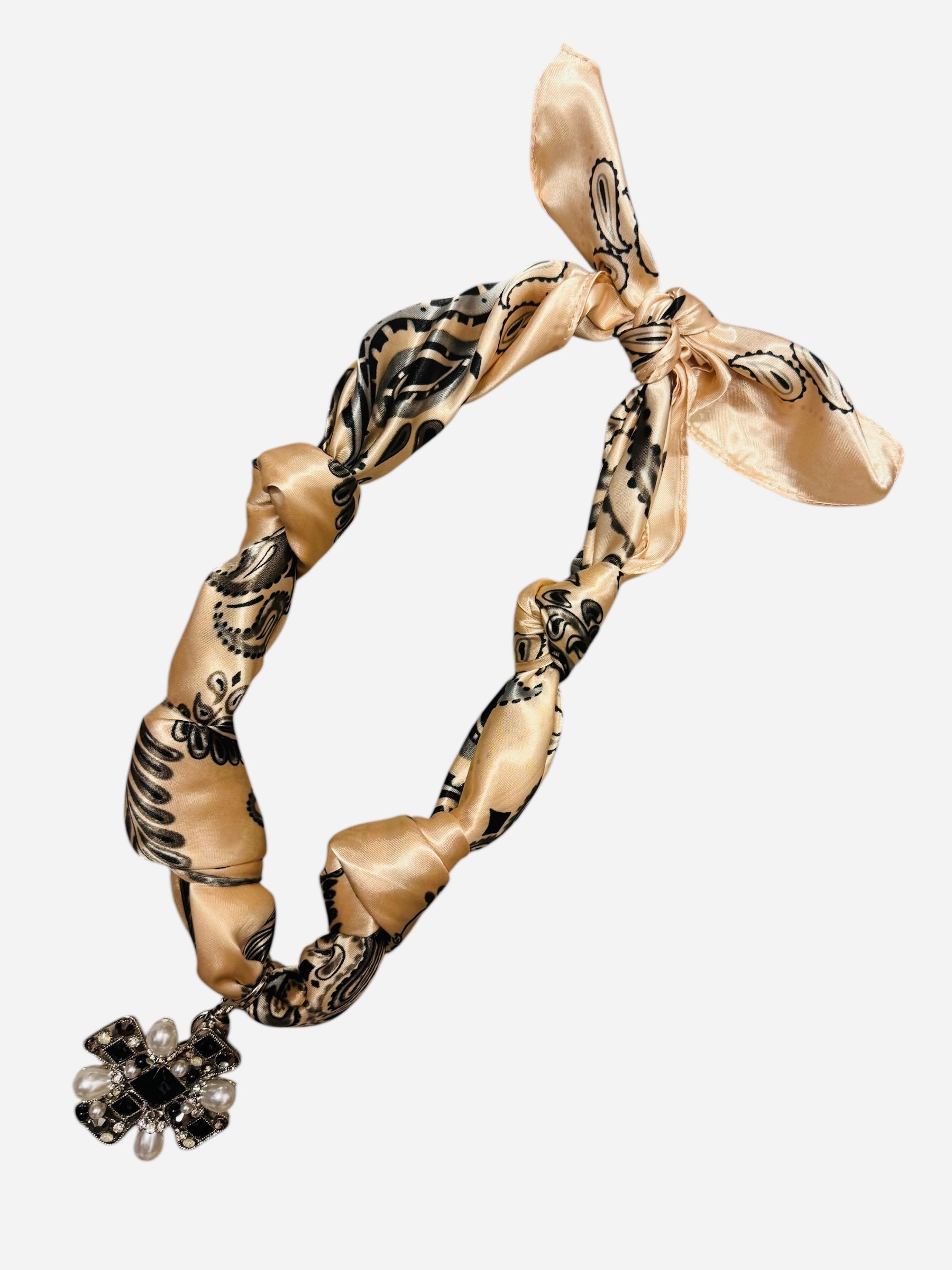 Beige silk bandana scarf with oversized cross charm, pearls, rhinestones, and adjustable knot design.