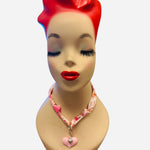 Pink and ivory floral scarf necklace with puffy pink heart charm and silver heart charm, tied in a stylish knot and designed to be worn as a necklace, bracelet, or accessory.
