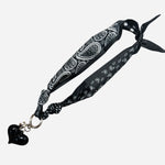 Double-sided black satin scarf with silver heart charm, dotted and bandana prints, chic Fall style.