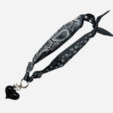 Double-sided black satin scarf with silver heart charm, dotted and bandana prints, chic Fall style.