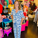 White pajama set with soft blue bow print, featuring a relaxed-fit short-sleeve top and matching pants made from lightweight, stretchy fabric for cozy comfort.