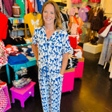 White pajama set with soft blue bow print, featuring a relaxed-fit short-sleeve top and matching pants made from lightweight, stretchy fabric for cozy comfort.