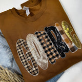 Mocha sweatshirt with plaid and sequin “GOBBLE” letters in warm gold, black, and beige.