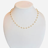 Gold-toned necklace with round beads and magnetic clasp on a delicate chain.