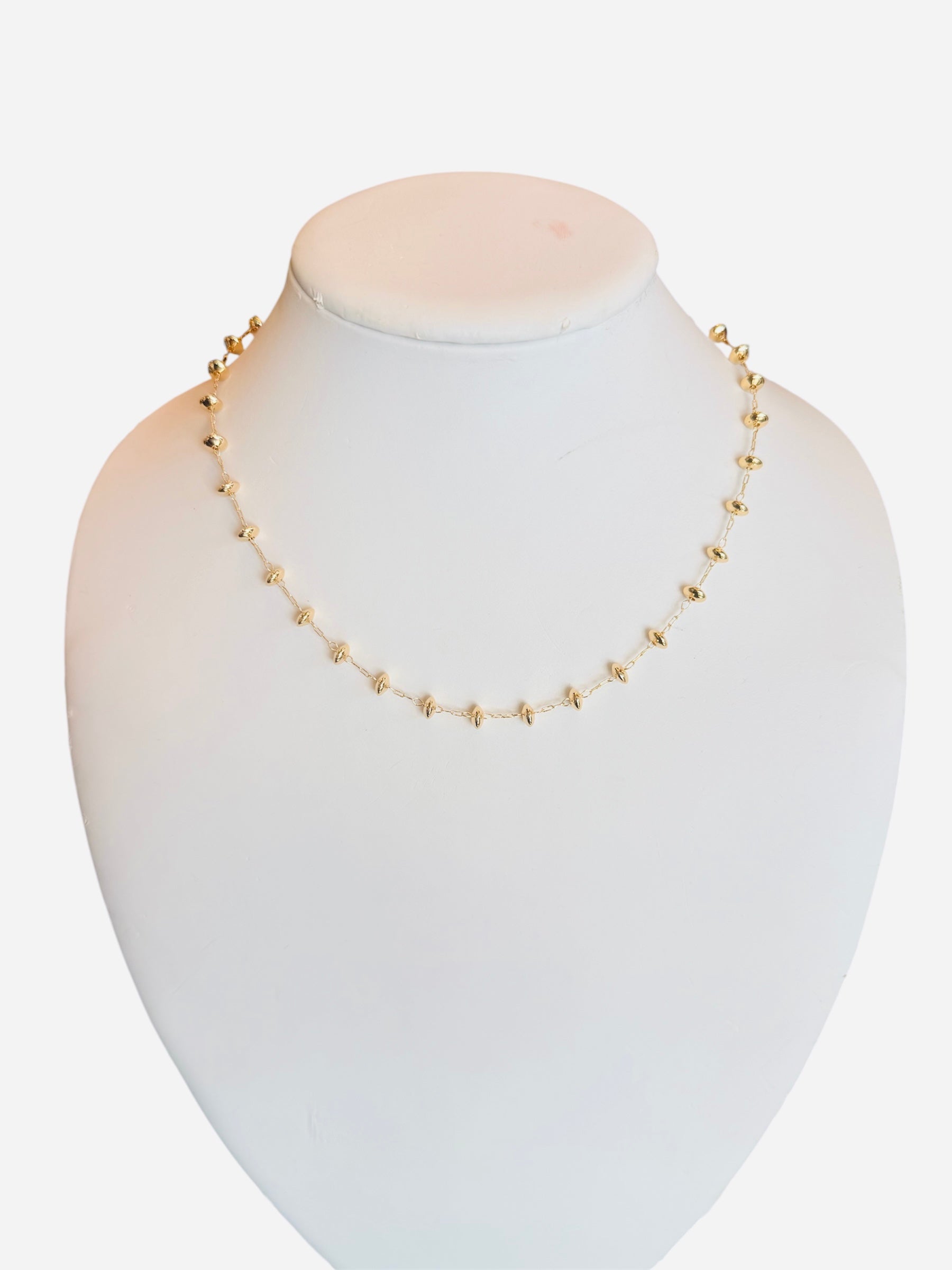 Gold-toned necklace with round beads and magnetic clasp on a delicate chain.