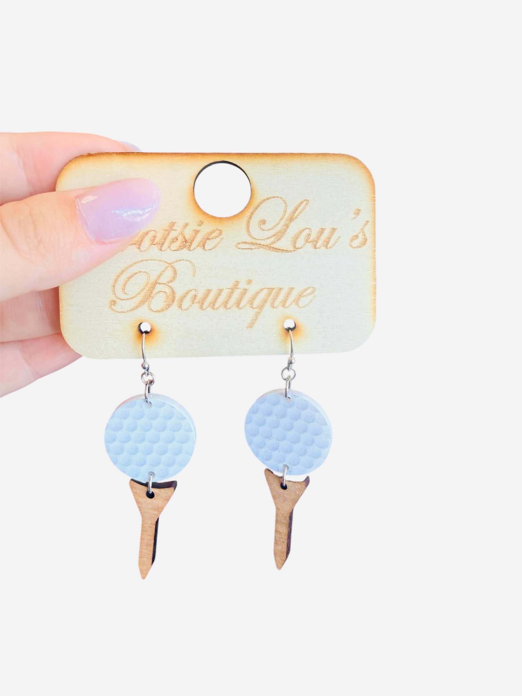 Golf earrings featuring white golf ball on wooden tee, lightweight and sporty accessory.
