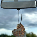 Heart-shaped leather and cowhide car freshener charm, handcrafted, reusable with scented oil mists, ideal for car, home, or camper.