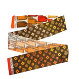 The Brown Travelers Scarf Tie features reversible floral and luggage tag prints — wear as scarf, twilly, or necklace.