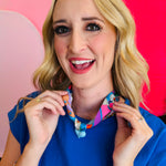 Close-up of model wearing the Blue Scarf Blue Heart Charm Necklace, featuring a soft blue printed scarf and glossy baby blue heart pendant—lightweight, adjustable, and perfect for adding a playful pop of color and charm to any outfit.