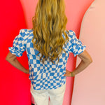 back view of baby blue short puff sleeve top in a baby blue and white checkered top with mock neckline