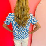 back view of baby blue short puff sleeve top in a baby blue and white checkered top with mock neckline