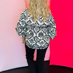 Rear view displaying allover black damask print and tailored back seam detailing