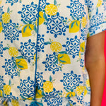 Detailed view of soft fabric texture, button front closure, and contrast piping.