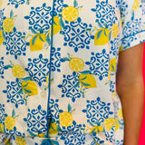 Detailed view of soft fabric texture, button front closure, and contrast piping.