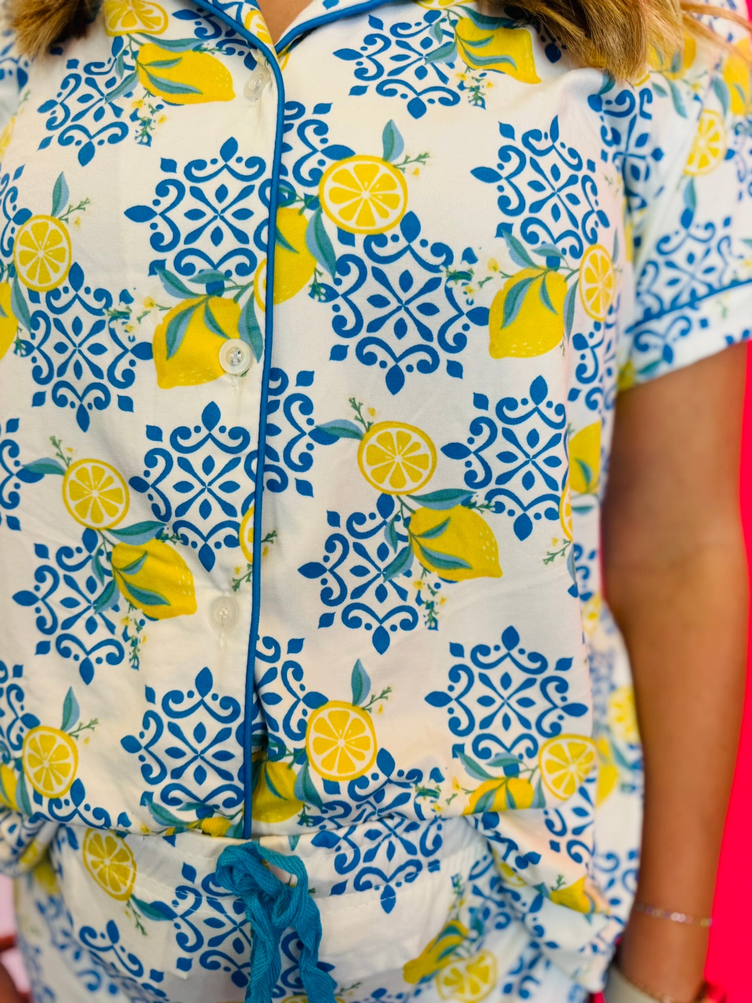 Detailed view of soft fabric texture, button front closure, and contrast piping.