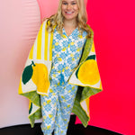 Soft blanket with playful allover lemon print in yellow and green on a white background.