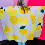 Soft blanket with playful allover lemon print in yellow and green on a white background.