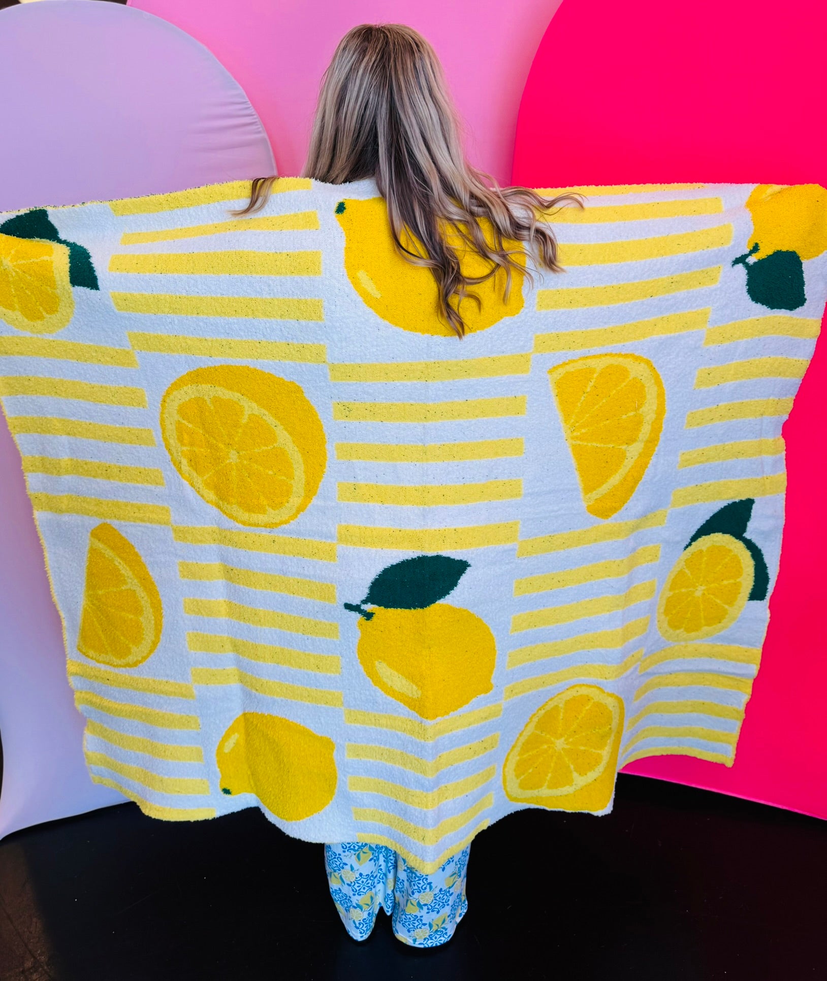 Soft blanket with playful allover lemon print in yellow and green on a white background.