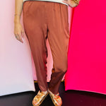 Cinnamon satin jogger-style pants with smocked elastic waistband, relaxed fit, and side pockets.