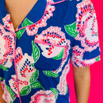 Button-front short sleeve top with classic collar, contrast piping trim, and smooth LuxBlend fabric.