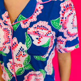 Button-front short sleeve top with classic collar, contrast piping trim, and smooth LuxBlend fabric.