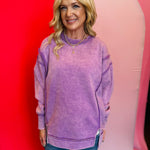 Violet acid wash fleece sweatshirt with exposed seams, relaxed fit, and side slits.