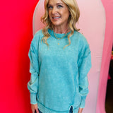 Turquoise acid wash fleece sweatshirt with exposed seams, relaxed fit, and side slits.